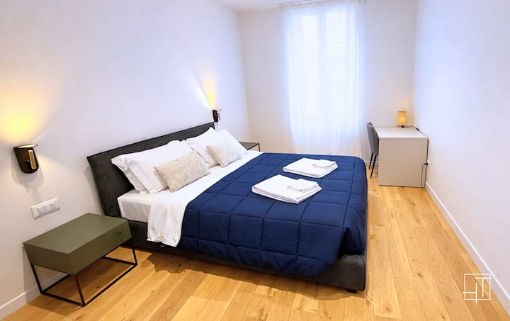 ფართო და ნათელი ოთახი კომფორტული ორსაწოლიანი საწოლით, ხარისხიანი თეთრეულით და რბილი განათებით. საძინებელში არის ტუმბოები და პრაქტიკული სამუშაო მაგიდა, რაც იდეალურ გარემოს ქმნის დასასვენებლად და სრული სიმშვიდით სტუმრობისთვის.