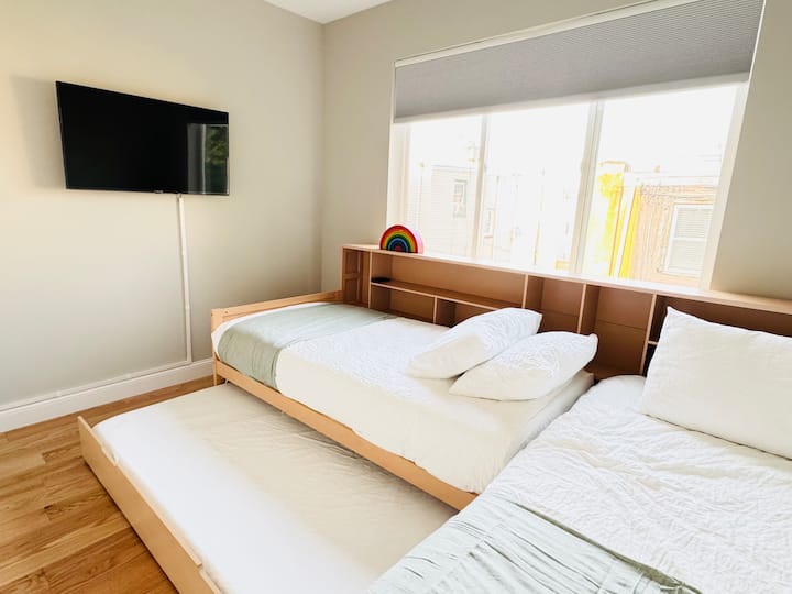 Spavaća soba na 2. katu s dva odvojena kreveta u obliku slova L i jednim pomoćnim krevetom na izvlačenje. Montiran je LG QLED TV od 43 inča.