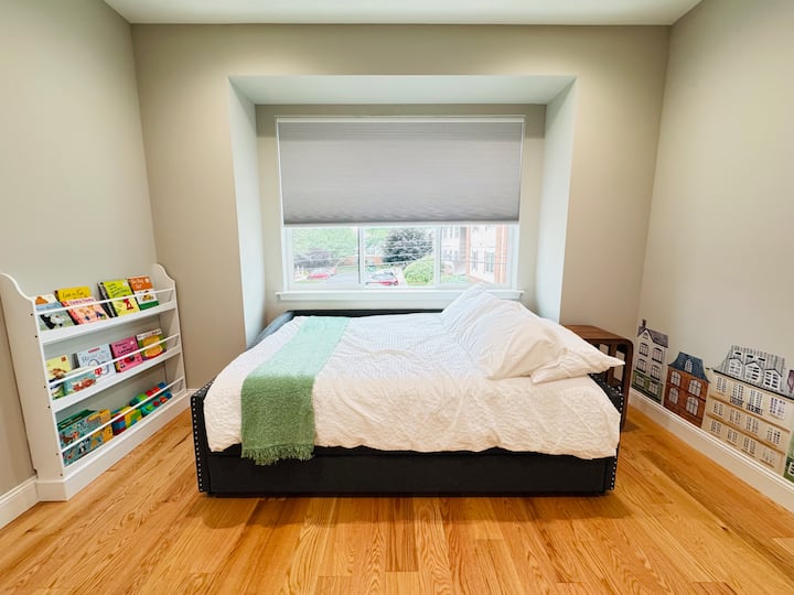 Veliki dnevni krevet s pomoćnim krevetom. Vrata za bebe na vratima ove spavaće sobe omogućuju malen siguran prostor za djecu u kojem mogu čitati knjige i igrati se igračkama.