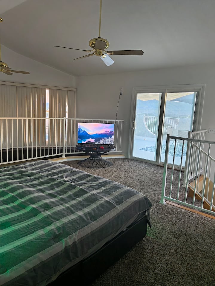 лофт главна спалня с голямо двойно легло и отделен балкон