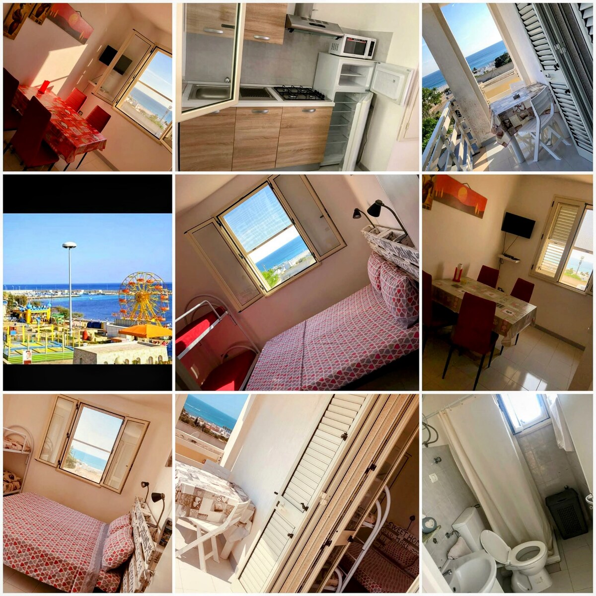 A bright and airy kitchen includes modern appliances, with a dining table set for four. A cozy bedroom displays a spacious bed with patterned bedding. A balcony offers a scenic sea view through a window, complemented by white furnishings and neutral tones throughout.