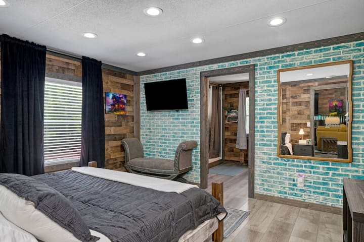 ห้องพักหลักพร้อมเตียงคิงไซส์ สมาร์ททีวี และผนังอิฐเทียมอันเป็นเอกลักษณ์ — เสน่ห์แบบชนบทพร้อมความสะดวกสบายทันสมัย