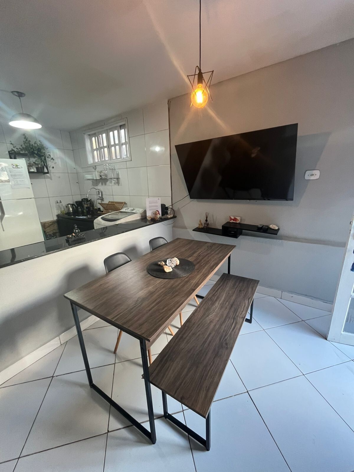 Bonito salón con Smart TV para streaming, mesa de comedor, banco y sofá de esquina 