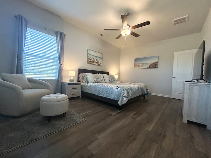 Large master bedroom with plenty of space to move around offers a 55 “ TV so you can relax in bed and maybe catch a movie on your favorite streaming service. A dresser, 2 nightstands and a  luggage rack as well allowing ample storage.