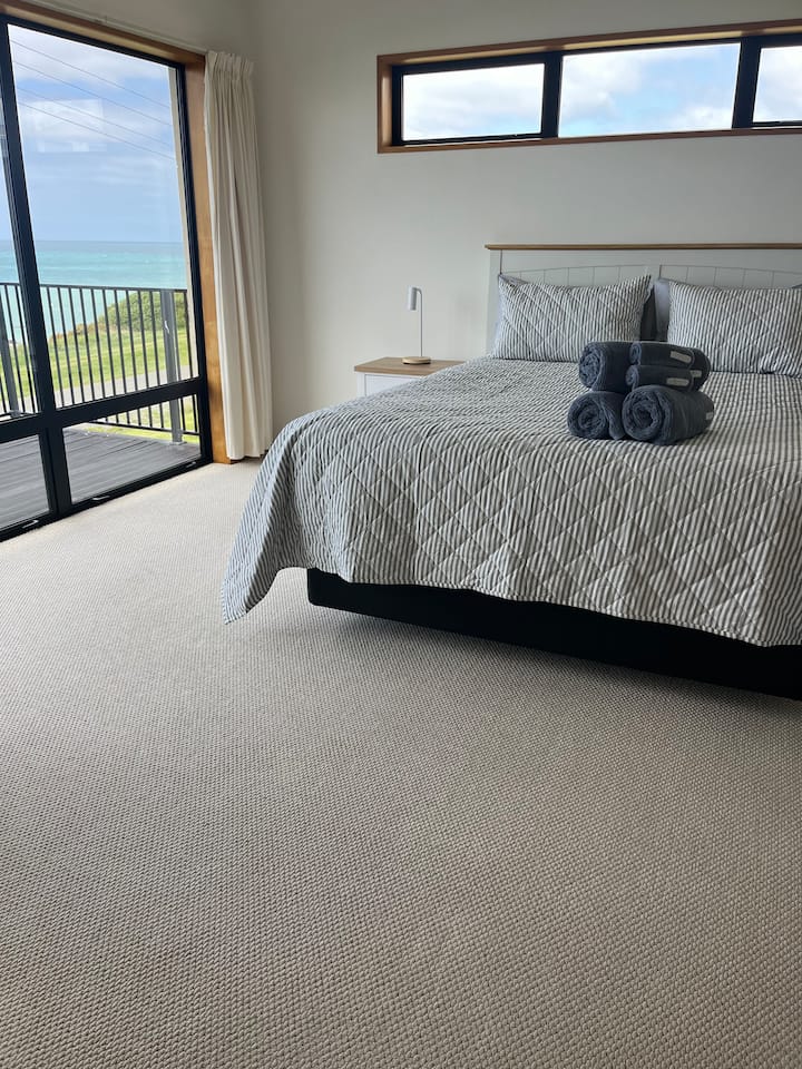 Dormitorio principal con baño y vistas al mar.