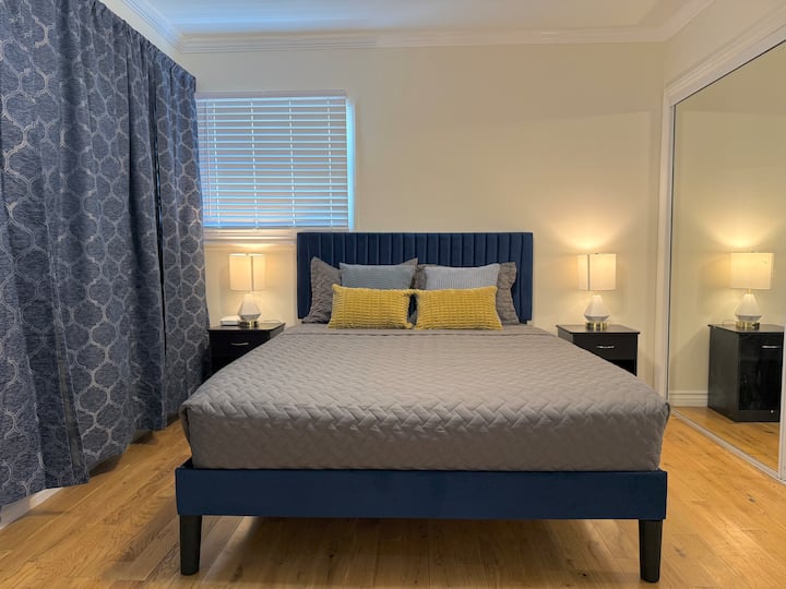 غرفة نوم رئيسية واسعة مفروشة بسرير بحجم متوسط