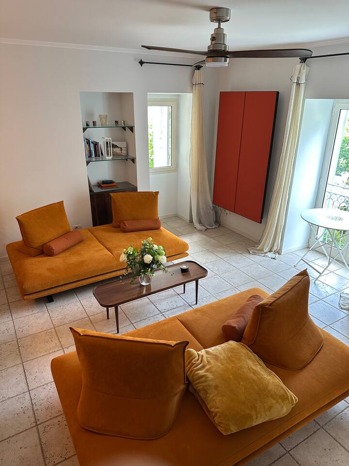 Dhoma e ndenjjes përbëhet nga dy divane Ligne Roset (120 cm të gjera) për të cilat ofrohet shtroja e veçantë krevati 

1 ambient studimi i montuar në mur (veçori portokalli në fotografi)

1 televizor i montuar në mur me shirit zëri dhe përforcues