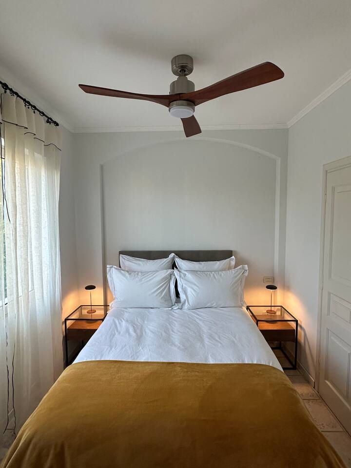 Krevat i vogël dopio, i ndërtuar në gardërobë dhe hapësirë të varur. Dritare dopio me grila, pamje nga kopshti i vilave, kodrat dhe Mentoni i vjetër