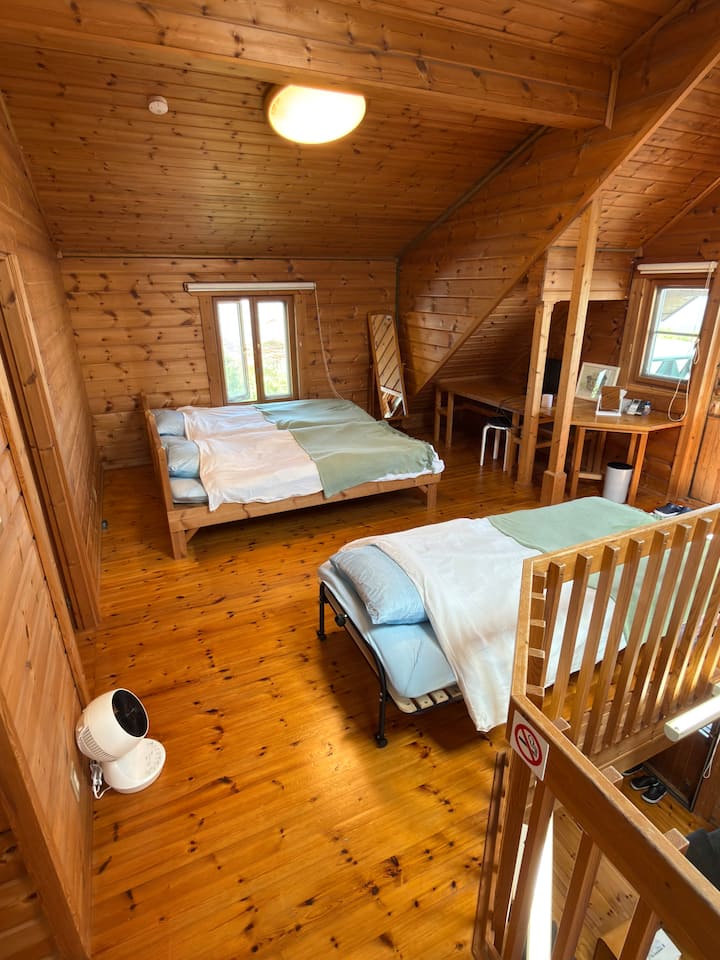 小屋内有一间令人放松的卧室，周围环绕着独特的天然材料。
木头的香味暗示并舒缓您的身心。
窗外是宁静的自然风光，让您享受如同在森林中睡觉般的奢华时刻。

忘记一天的喧嚣，体验深沉而愉悦的睡眠。
清晨醒来，鸟儿在唱歌，阳光洒满屋子。