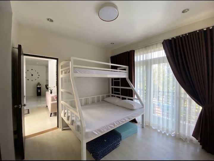 Dormitorio en el piso principal con baño completo y balcón con vistas a la terraza de la piscina.