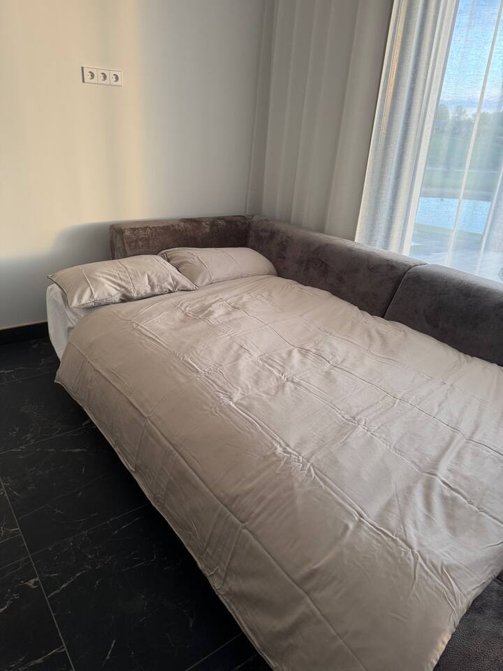 ფართო და კომფორტული დივანი-საწოლი (160×200 სმ) სპეციალური მატრასით — მყუდრო ადგილი, სადაც მოგზაურობის შემდეგ განტვირთვას შეძლებთ.
გასაშლელი დივნები განთავსებულია ერთ დიდ ღია სივრცეში, ცალკე ოთახების გარეშე — ინტერიერი ნათელი და ჰაეროვანია.
