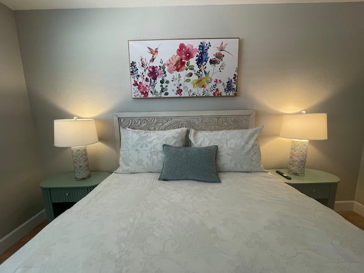 Hermoso dormitorio tamaño queen con cabecera de madera tallada detallada y vestidor grande.