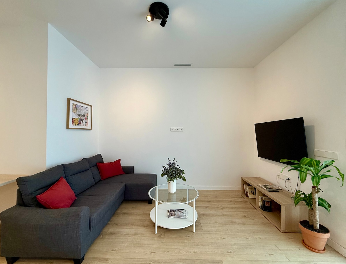 SALÓN-COMEDOR: Sofá cama doble, creando un ambiente íntimo con una mesa baja y una TV tipo Smart para disfrutar. Espacio con aire acondicionado por conducto.