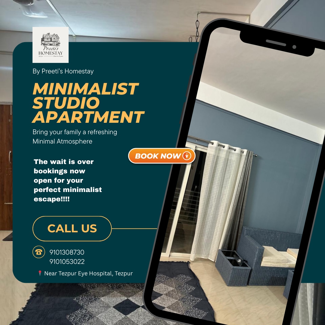 A minimalist studio apartment features neutral-toned walls and a spacious layout. Natural light fills the room through a large window adorned with soft drapes. A comfortable bed is positioned against one wall, complemented by a cozy seating area and a small kitchenette.