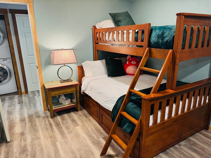 Un espacio acogedor y versátil con una cama doble sobre una litera completa, un cómodo sillón reclinable para relajarse y un armario para todos tus elementos esenciales.