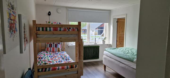 Spálňa s poschodovou posteľou určenou pre deti/mládež, ako aj posteľ pre dospelých, tiež otvorený šatník