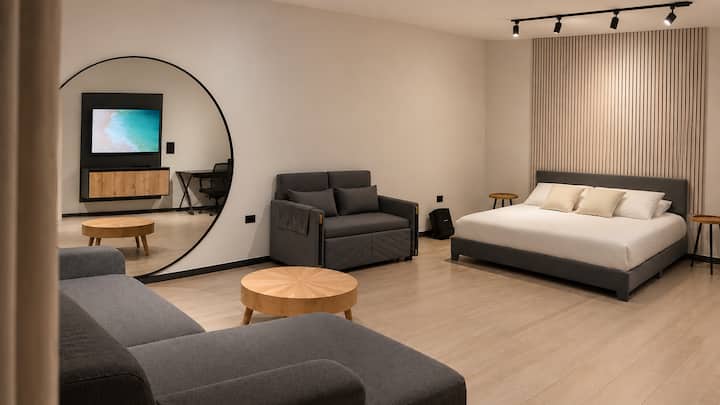 Sua suíte master inclui um grande espelho elegante e uma ampla área de estar, com espaço para relaxar além da cama.