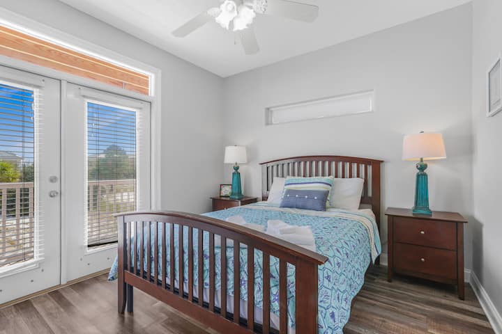 Despiértate con luz natural y sal al balcón desde este acogedor dormitorio diseñado para el relax