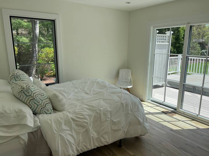 ห้องนอนที่เต็มไปด้วยแสงสว่างพร้อมประตูแยกต่างหากไปยังระเบียง (และที่อาบน้ำฝักบัวกลางแจ้ง) พร้อมเตียงเต็มรูปแบบ 