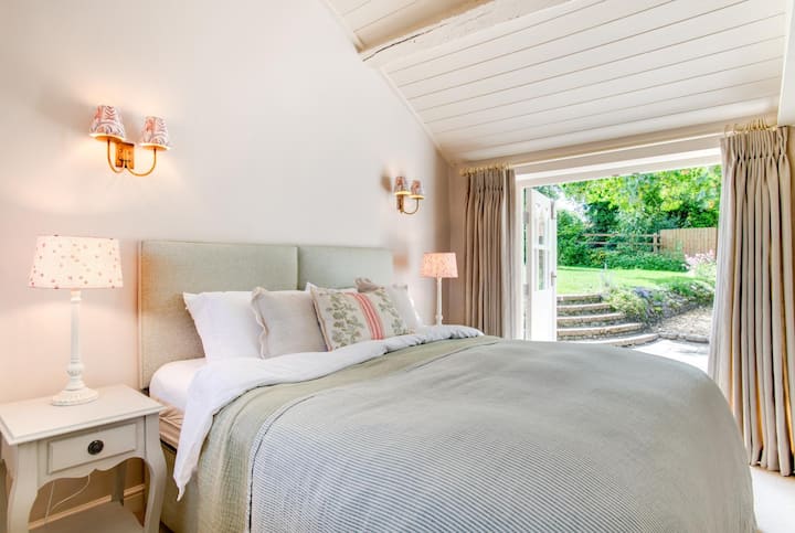 Chambre au rez-de-chaussée avec salle de bains privée. Les portes-fenêtres donnent sur le jardin.