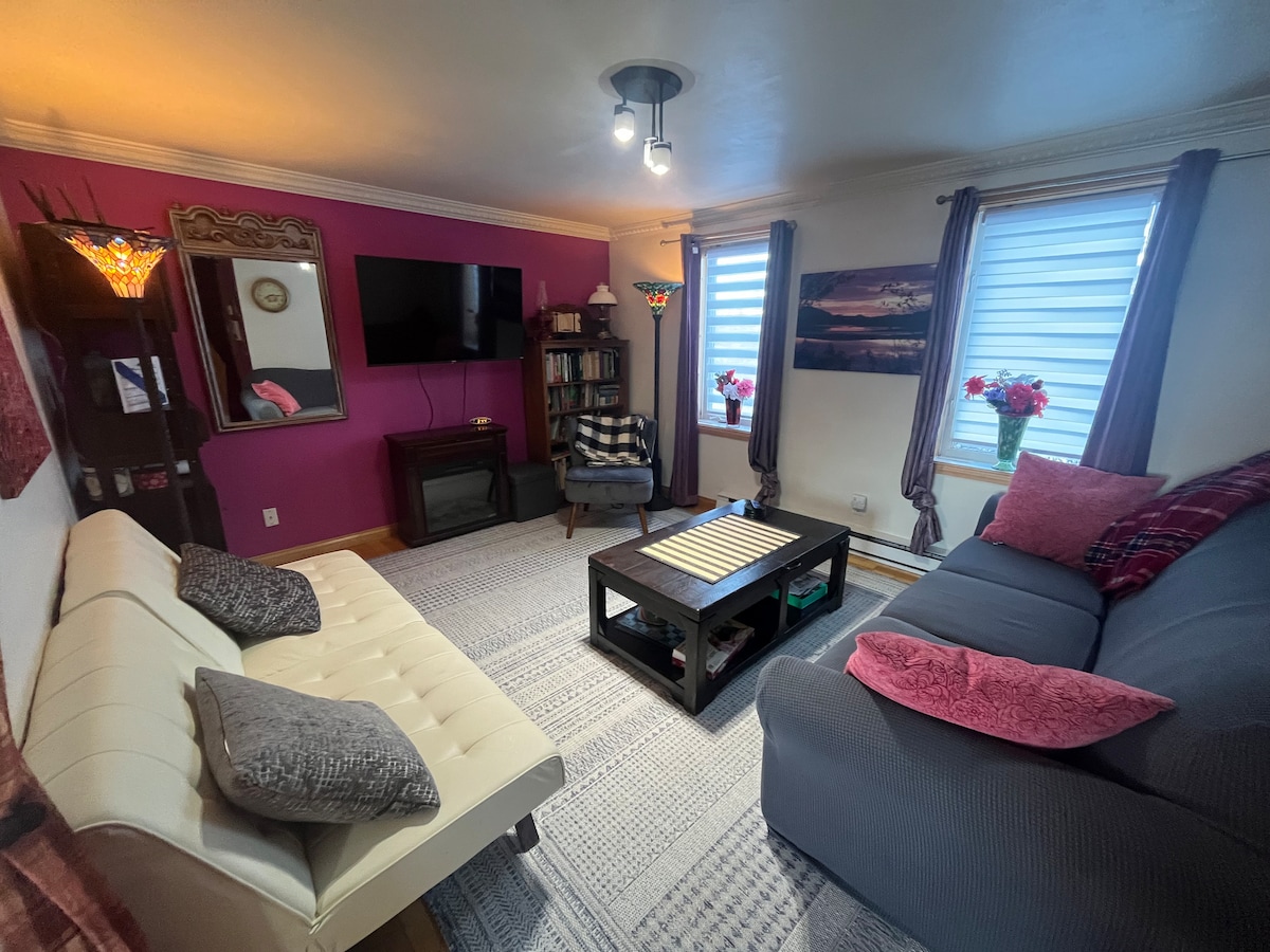 Komfortables Wohnzimmer/Salon mit Schlafsofa, Lesestuhl, 2. Sofa, Großbildfernseher, elektrischem Kamin, Couchtisch, Blick auf die Berge.