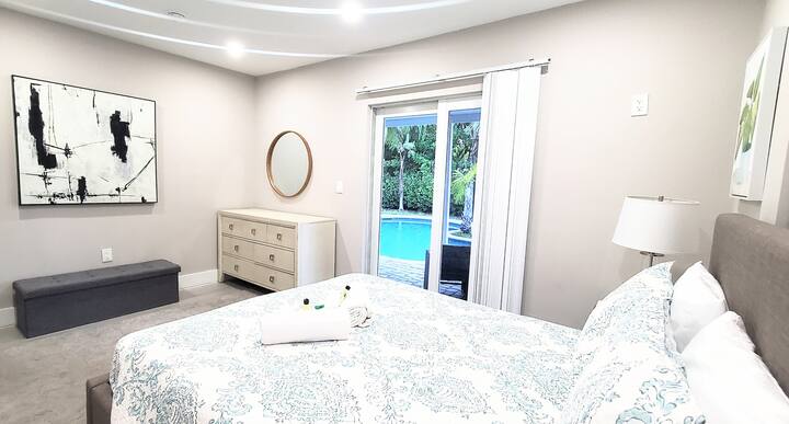 Ნათელი და მშვიდი საძინებელი ოთახი აუზის ხედით აღჭურვილია კომფორტული ორადგილიანი საწოლით , უშუქო ფარდებით, კომოდი სარკით, დამატებითი საბნები და პირდაპირი წვდომა ტროპიკულ უკანა ეზოსა და აუზზე , რომელიც იდეალურია თქვენი დღის მშვიდად დასაწყებად.