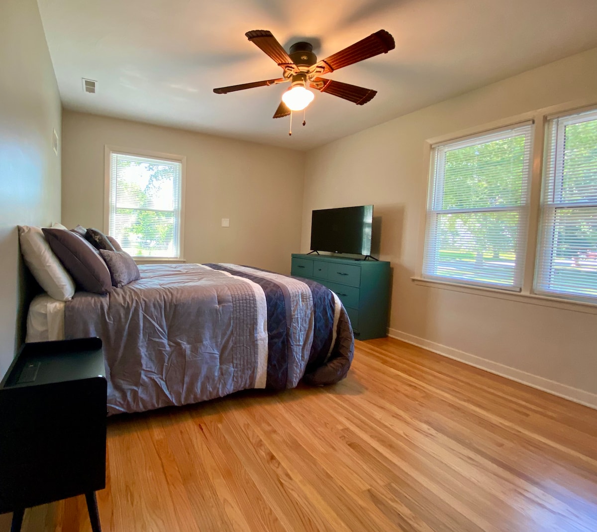 Ruime primaire slaapkamer met queensize bed en veel natuurlijk licht.