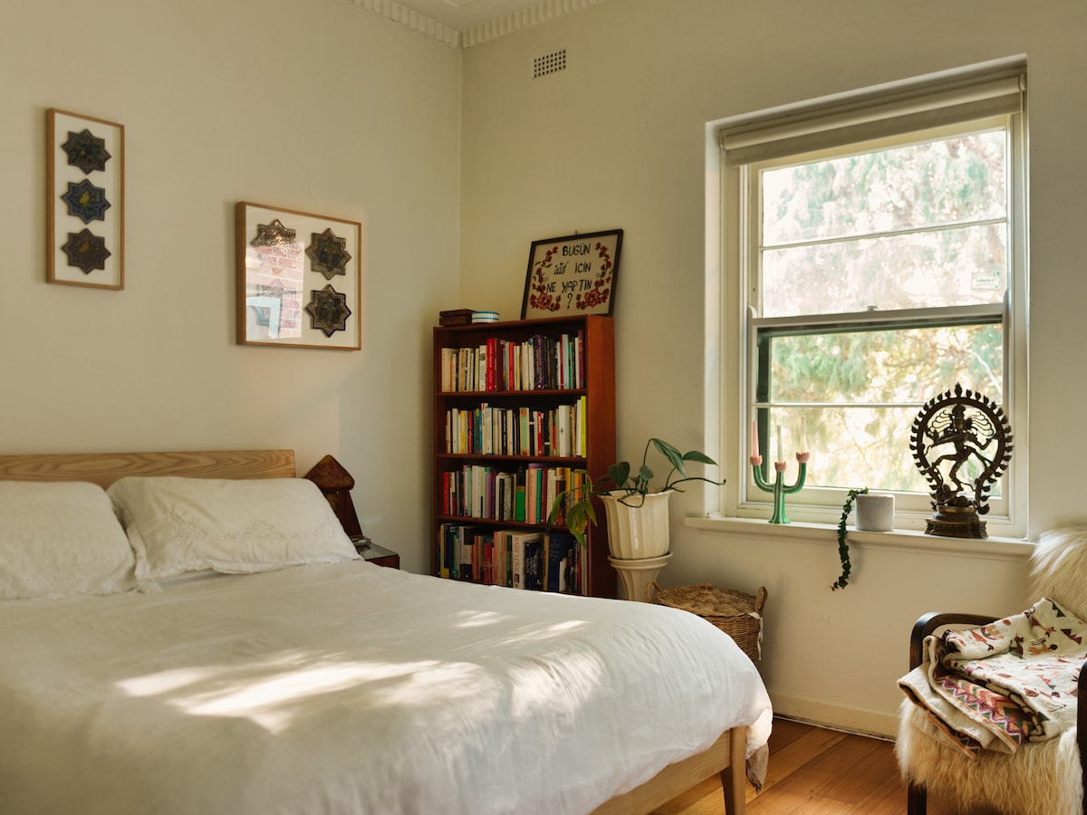 Our incredibly comfortable Queen-size bed sits beneath framed antique Iranian tiles and a lamp made of green onyx from Saudi Arabia. 