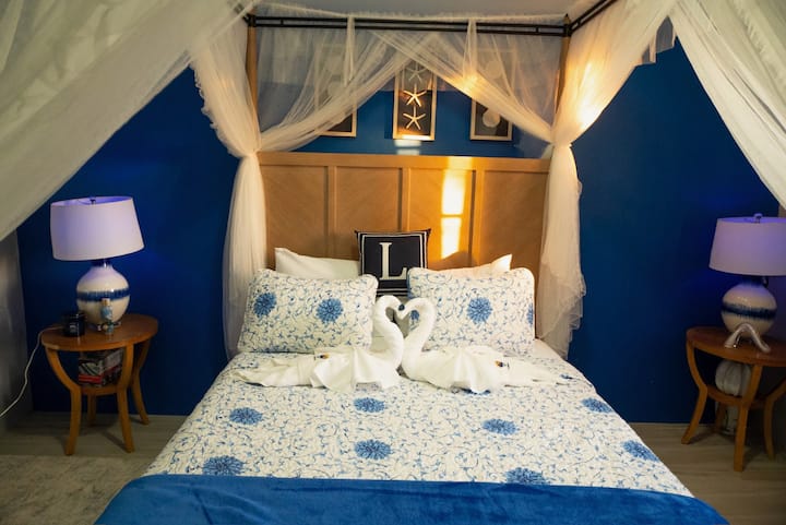 Rest easy in our primary bedroom, featuring a plush King bed, air conditioner, and plenty of natural light for a peaceful island slumber.