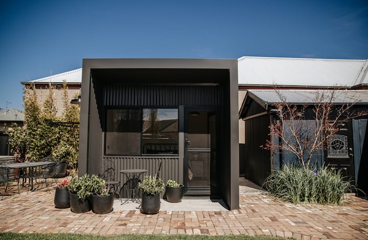 Vitajte v našej exteriérovej spálni. Iba manželská posteľ a bočné stolíky – hostia musia používať vnútornú kúpeľňu