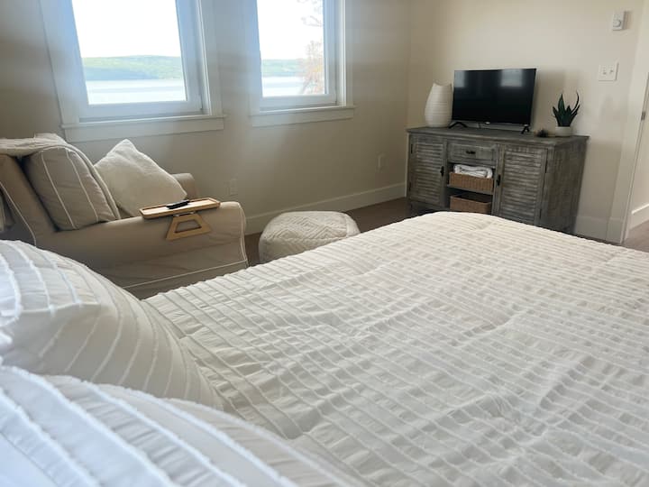 Mwonekano wa Ziwa - Likiwa kwenye ghorofa ya pili, chumba hiki cha kulala kina mandhari tulivu ya ziwa. Chumba hiki cha kulala kina kitanda chenye starehe cha ukubwa wa malkia, kiti chenye starehe cha kuteleza/kutikisa na televisheni; kinachotoa mchanganyiko kamili wa starehe na uzuri wa mandhari.