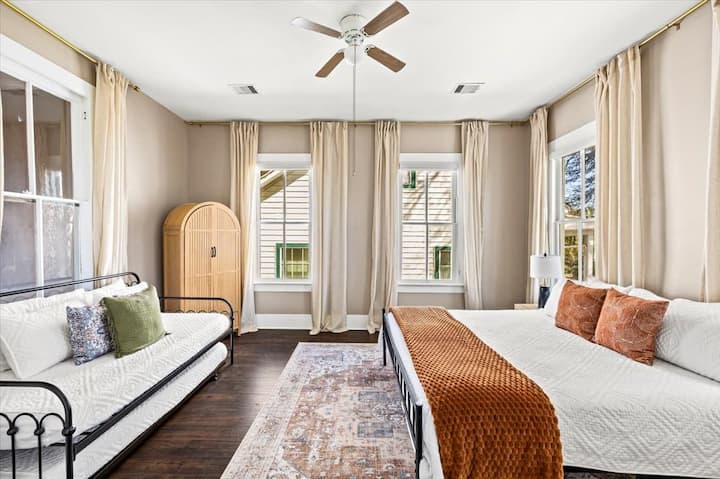 Una luminosa suite familiar de 1886. Este versátil dormitorio en la planta superior cuenta con una cama tamaño king y un sofá cama individual con cama corrediza, lo que ofrece un alojamiento acogedor y luminoso para un máximo de 4 huéspedes en Sand and Sea Manor, a pocas cuadras de la playa de Galveston.
