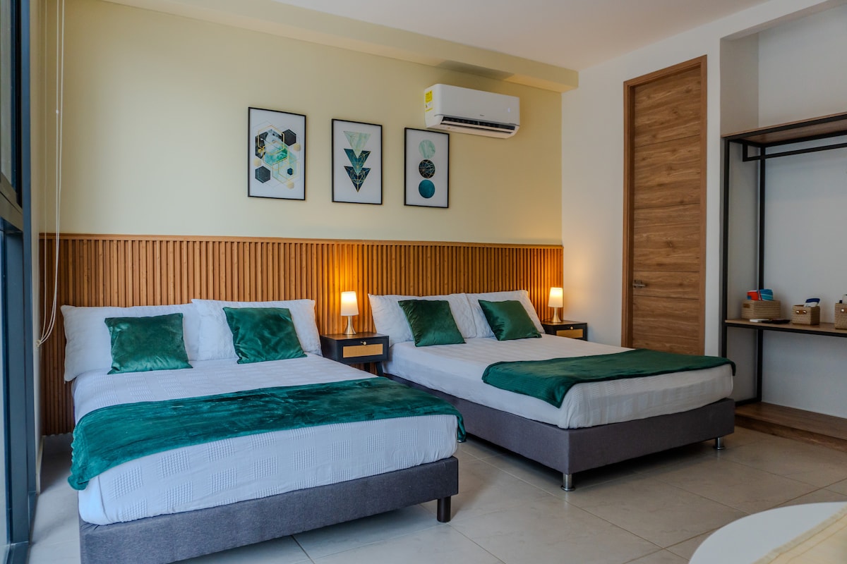 جناح يحتوي على سريرين مزدوجين كبيرين وبياضات ناعمة وتفاصيل زخرفية تلهم الراحة. مجهزة بمكيف هواء ومصابيح دافئة وإكسسوارات حديثة تضمن إقامة مريحة ومريحة بالقرب من الشاطئ.