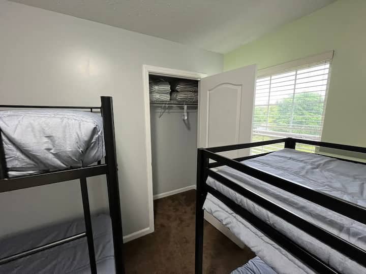 Dos camas de una plaza, una cama nido de una plaza debajo de una de las camas de una plaza.