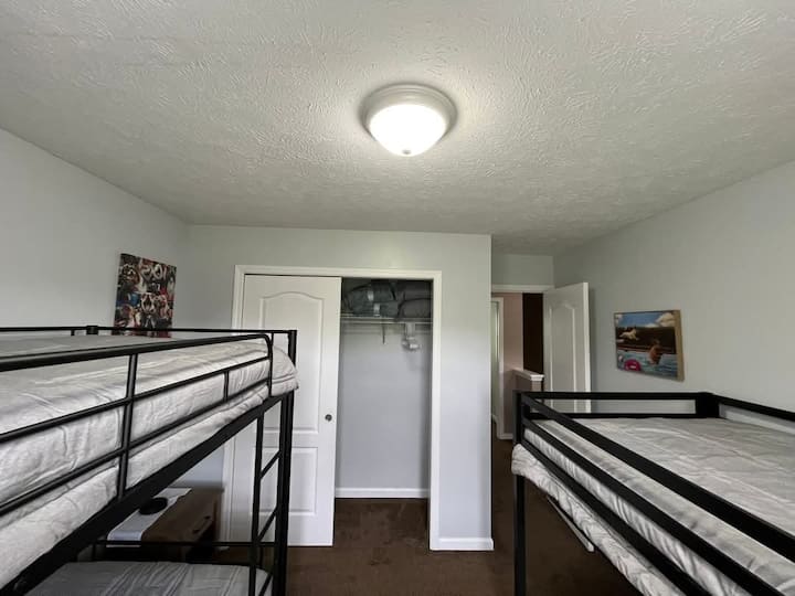 Dos camas de una plaza, una cama nido de una plaza debajo de una de las camas de una plaza.