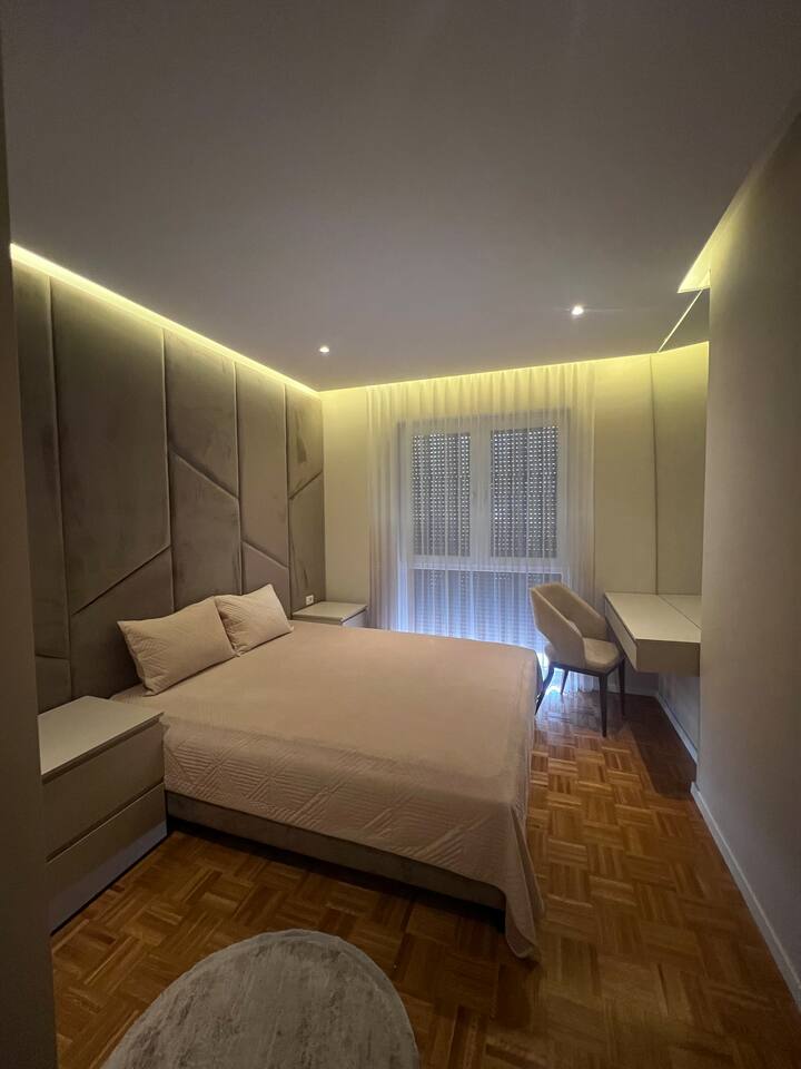 ห้องนอนหรูหรา มีแสงไฟส่องสว่างเตียงคู่ที่สะดวกสบาย โต๊ะข้างเตียงสองข้าง ตู้เสื้อผ้ากว้างขวางมีพื้นที่เก็บของมากมาย และเก้าอี้ที่โต๊ะทำงานที่เหมาะสำหรับการเตรียมตัว