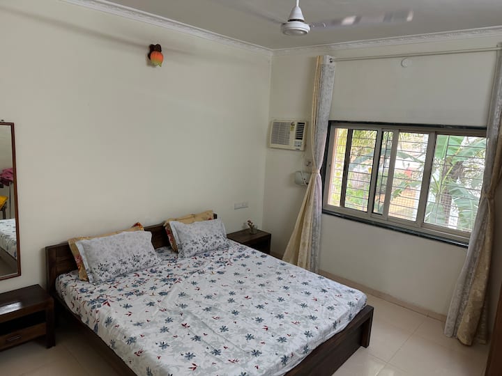 Dhoma e gjumit në katin përdhes ka një mobilim të rehatshëm me një kondicioner dritareje, një dollap të gjerë dhe një komo me pasqyrë të plotë. Dritarja e dhomës hapet me pamje nga oborri i pasmë me pemë frutore, duke ofruar një qëndrim të qetë dhe freskues.