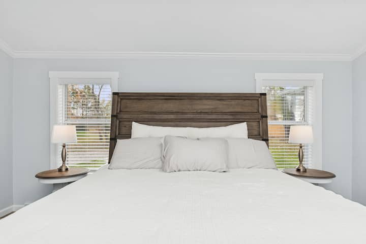 King-size luxury mattress with premium linens and touch-control lamps.