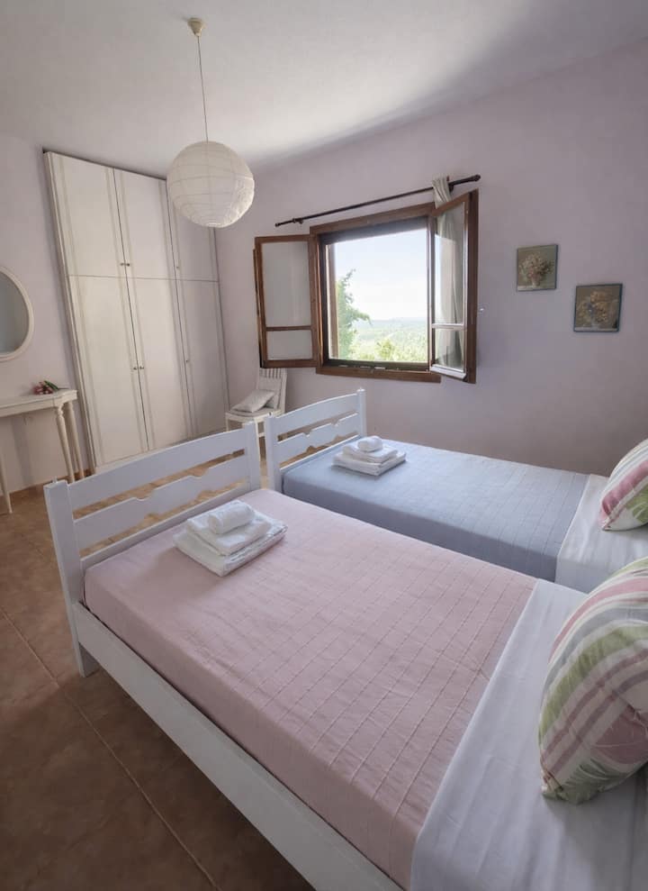 Chambre lumineuse à l'étage avec deux lits simples donnant sur la mer et le jardin. La chambre dispose de grandes armoires, de la climatisation et d'un accès facile à la deuxième salle de bain, ce qui la rend confortable pour les courts et longs séjours.