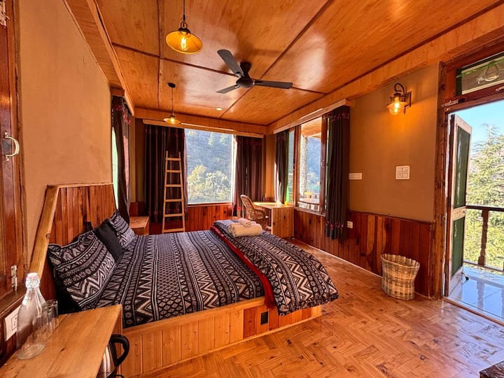 The Super Deluxe — three-side panoramic windows, wooden floors, and the river always in earshot
