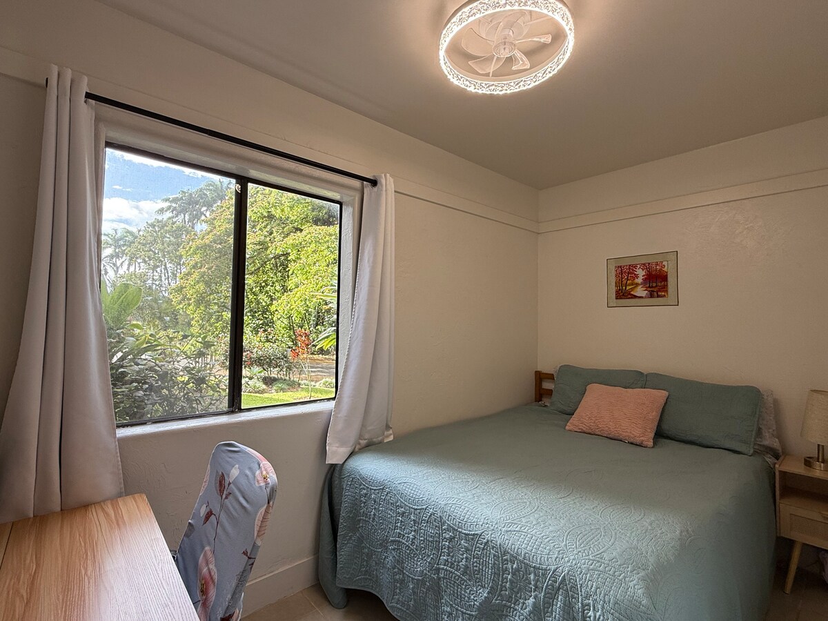 Bračni krevet s pogledom na vrt i djelomičnim pogledom na ribnjak, veliko radno mjesto s monitorom, stropni ventilator i stolni ventilator. (stropni ventilator ima 2 smjera strujanja zraka: hladno ili toplo (odvlaživanje))