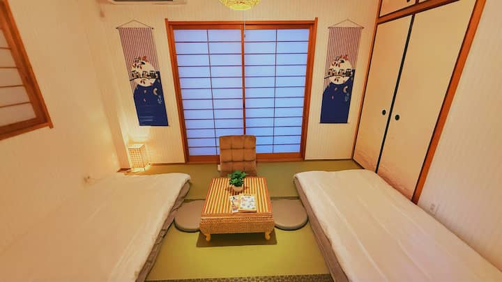Udobna soba s tatamijima u japanskom stilu s udobnim futonom i prigušenim svjetlom, savršena za miran odmor i opuštanje.