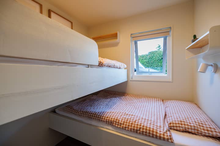 Компактна и забавна, стаята е направена по мярка за двуетажните легла. Всяко легло има лампа за четене и малък рафт. Съхранението на дрехи е в основната спалня.