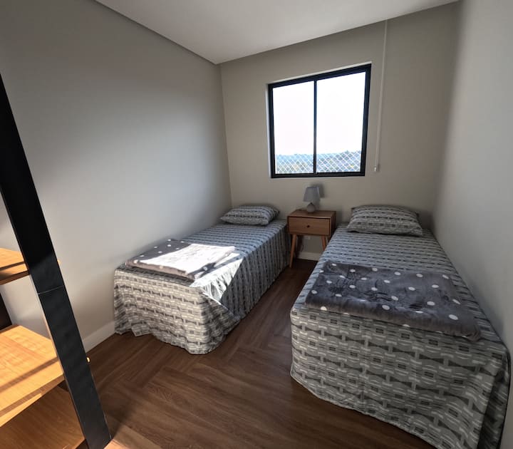 ห้องพักที่มีเตียงเดี่ยวสองเตียงและตู้เสื้อผ้า 