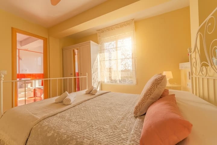 Dormitorio al atardecer con luz dorada.