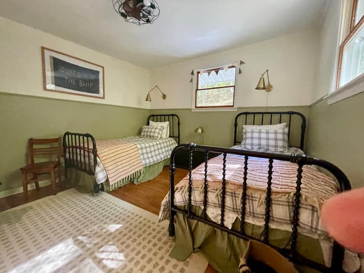 The twin bedroom has two comfortable single beds with individual reading lamps, and a cozy reading nook on the back wall. The rug gives some good quiet indoor playspace, too! 