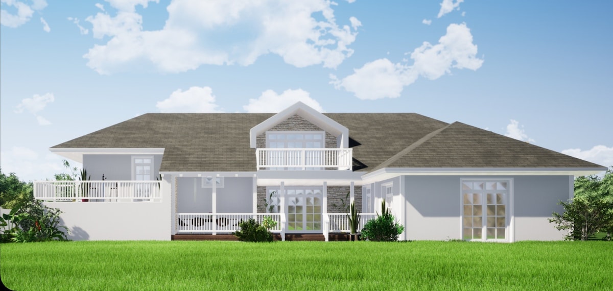 A spacious two-story house is shown with a light-colored exterior and a broad, sloped roof. Large glass doors provide access to a charming outdoor area, surrounded by green grass and blooming plants. Clear blue skies are visible in the background.