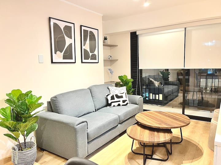 Ნათელი ოთახი თანამედროვე ავეჯით, იდეალურია ფეხით სიარულის ან მუშაობის შემდეგ დასასვენებლად.