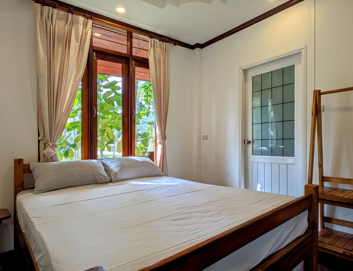 ️ Dormitorio secundario con cama matrimonial y vistas a la naturaleza.