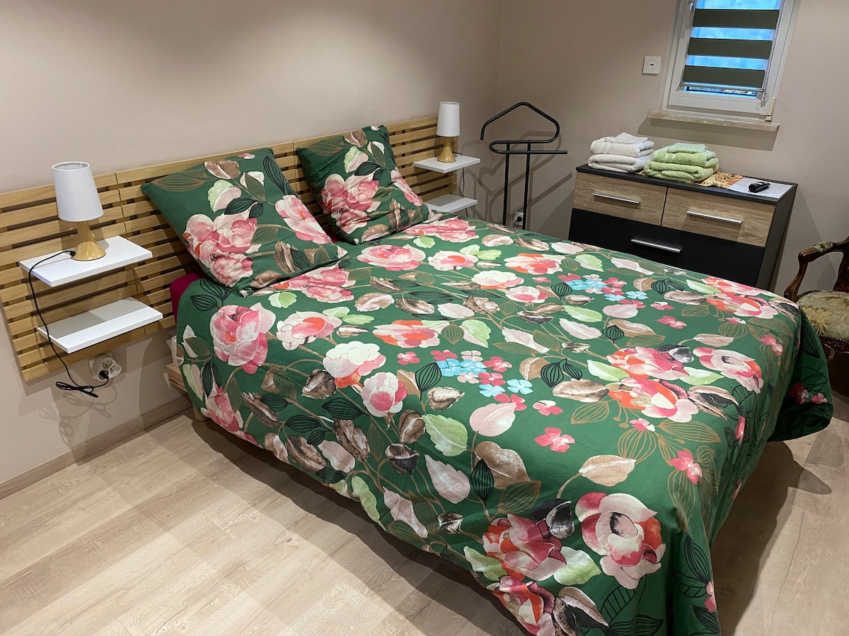 De slaapkamer is uitgerust met een tweepersoonsbed van 140 x 190 cm, twee nachtlampen, een dressoir en een valetstandaard. 